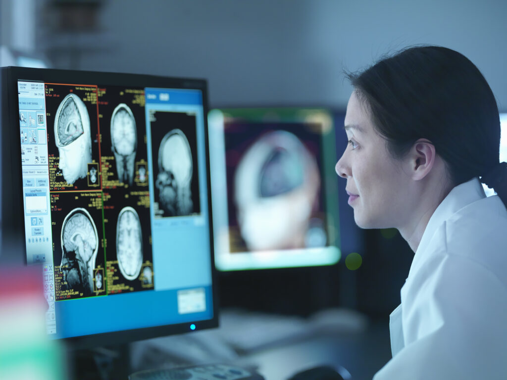 Scientist looking at brain imaging on computer screen in lab. | Netherlands oncology