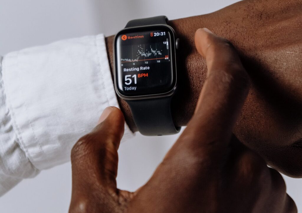 Person Wearing Silver Aluminum Case Apple Watch With White Sport Band using the heart rate app