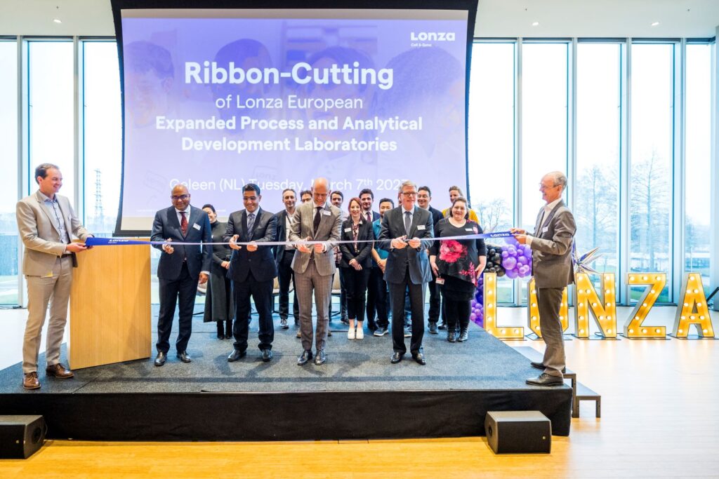 Group of business professionals cut the ribbon on the new Lonza facility in the Netherlands