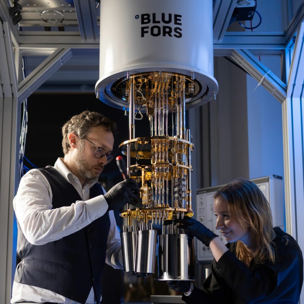 Man and woman work on a piece of Bluefors equipment