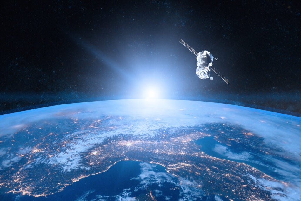 Earth from above with space craft seen in orbit. 