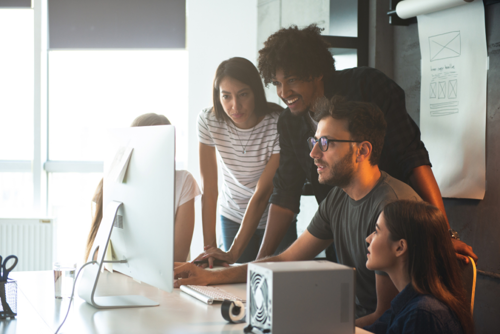 A group of people looking at a computer. Invest in Holland.
