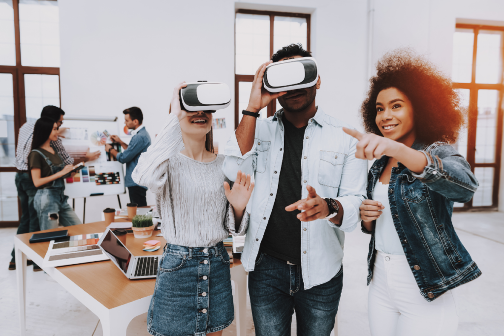 Two people wearing augmented/virtual reality headsets together with one woman. Invest in Holland.